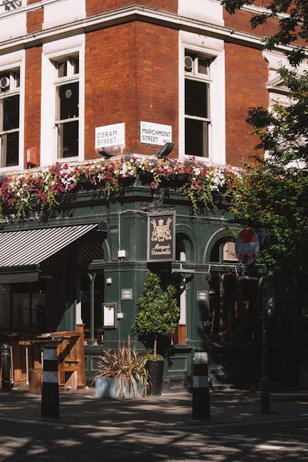 The image shows the entrance to Borough Market in Southwark, London, with a prominent white sign reading 'Borough Market' in bold black letters hanging beneath a green-framed canopy. The market's stru